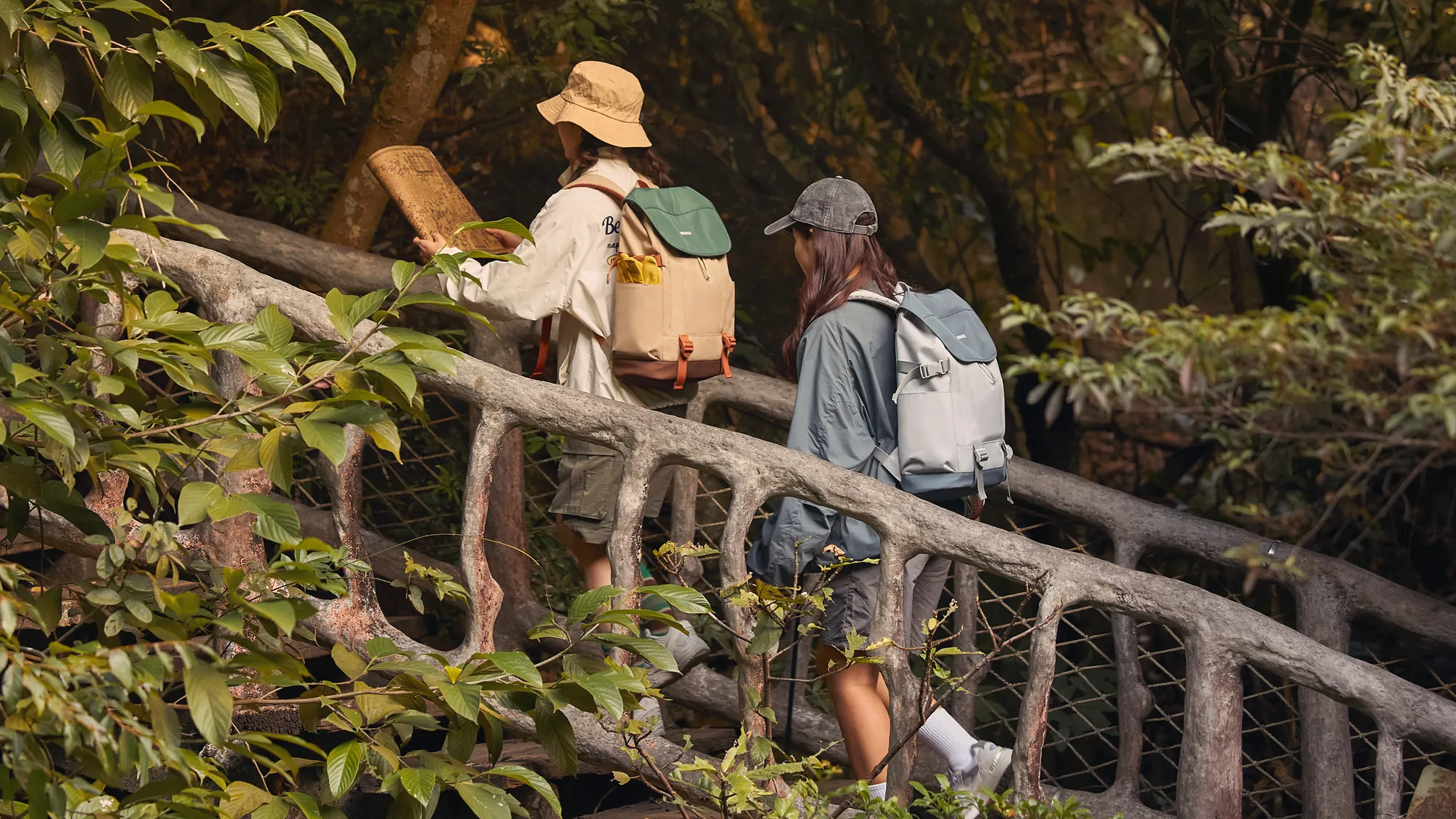Friends crossing a wooden bridge with Mr.ace Homme backpacks